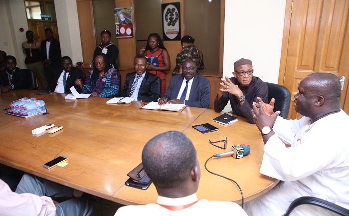Mr Kenneth Ashibey (right), the MD, GCGL, addressing the Minister of Information and his delegation when they visited the company at the head office in Accra.
